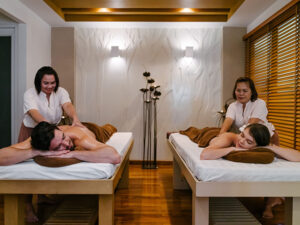 Couple receiving side-by-side spa treatments