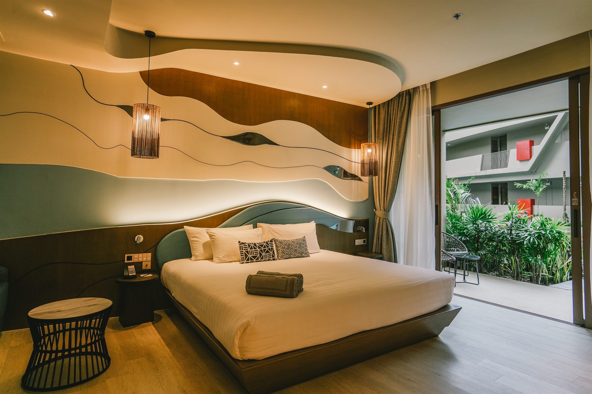 Contemporary guest room with a large bed and outdoor terrace at Metadee Concept Hotel