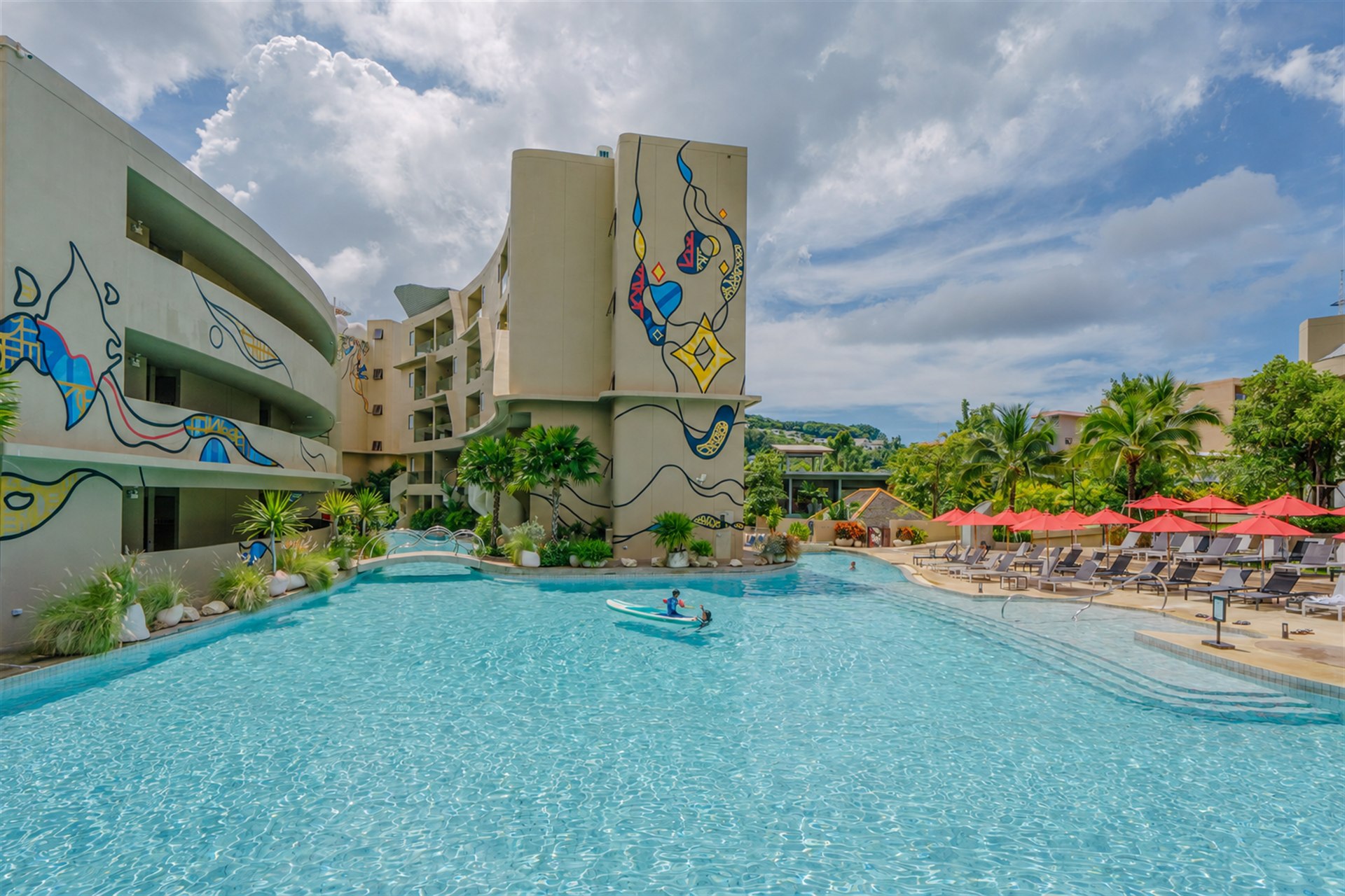 Contemporary resort buildings with colourful murals surrounding the main pool at Metadee Concept Hotel in Phuket