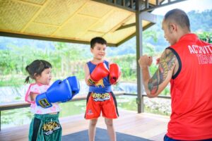 Children practising Muay Thai with a Metadee activity team member