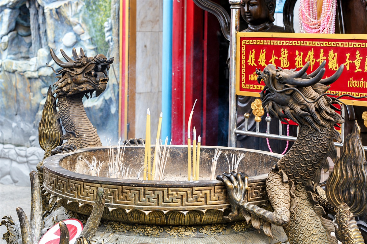 Dragon-shaped incense burner with burning incense at a Phuket Chinese shrine