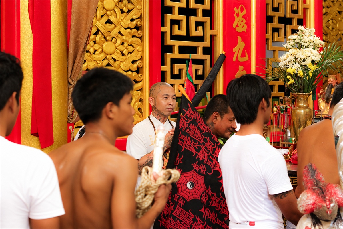Devotees gathered before a richly decorated Chinese shrine during the Phuket Vegetarian Festival