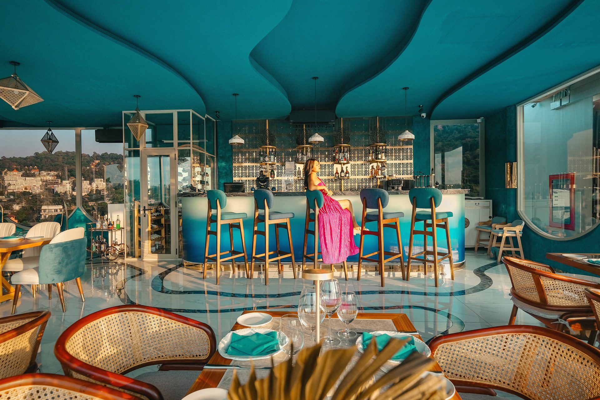 A Rooftop Moment at Moon Terrace Phuket Guest seated at the turquoise Moon Terrace rooftop bar with hillside views